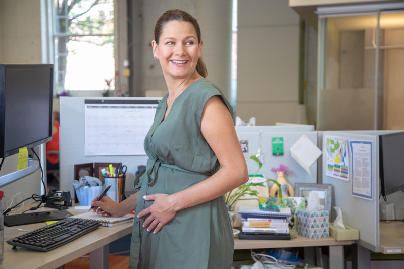 Pregnant working mother at her office desk