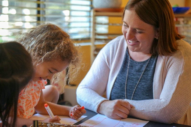 K Prep teacher helping students to write