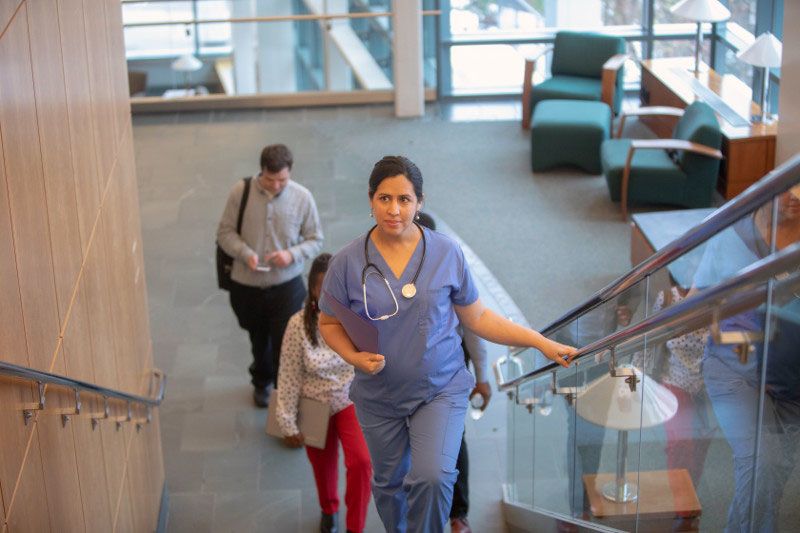 Pregnant nurse walking up the hospital stairs