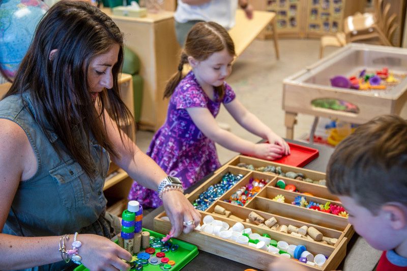 Child care teacher doing crafts with her preschoolers