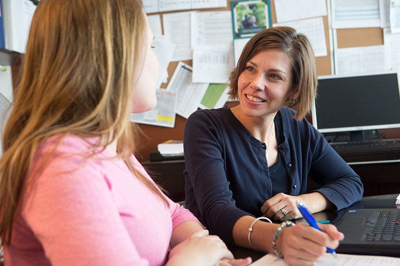 College admissions counselor helping a high schooler