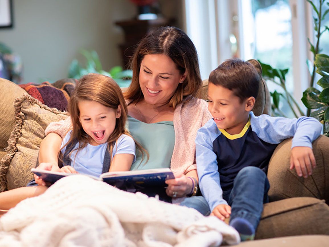 Mom reading with her two kids at home