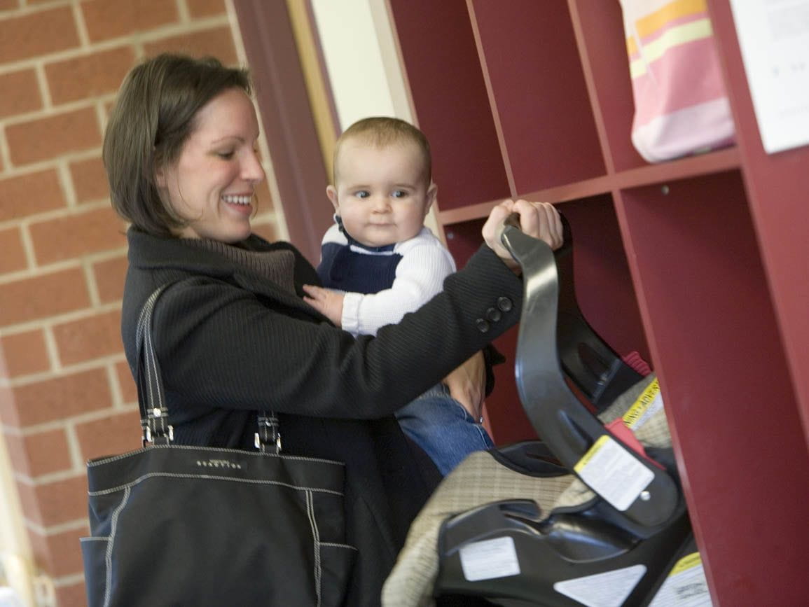 A mother dropping off her infant at child care in the morning