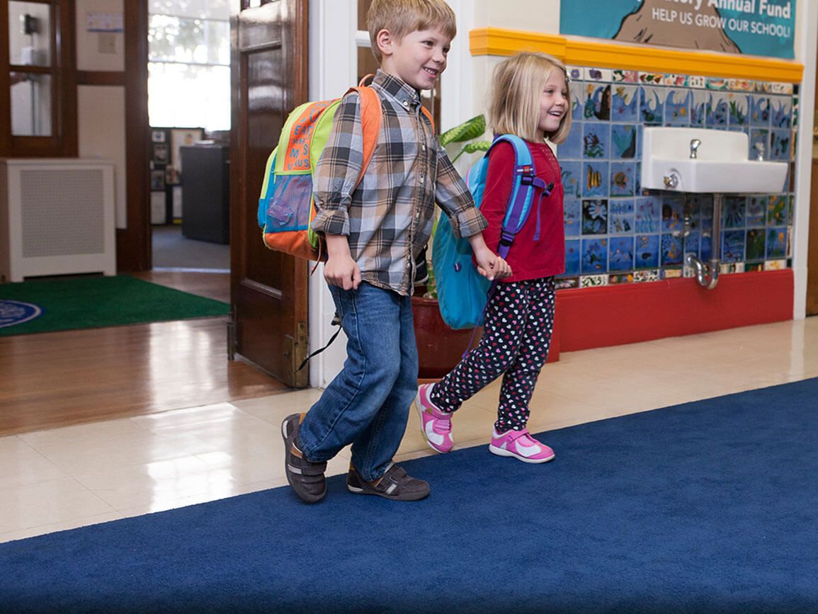 Two children ready for school walking into Kindergarten