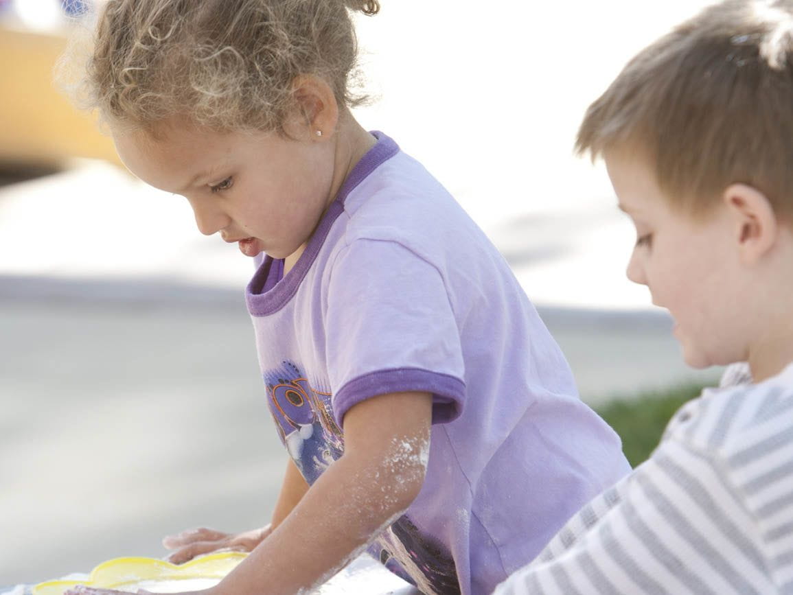 Kindergarten-aged boy and girl playing together