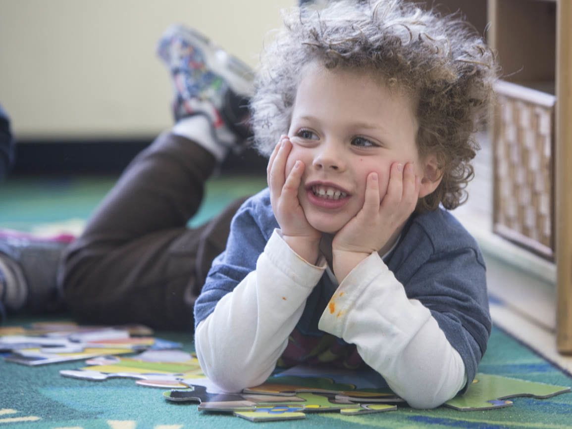 Preschool boy lounging on a mat