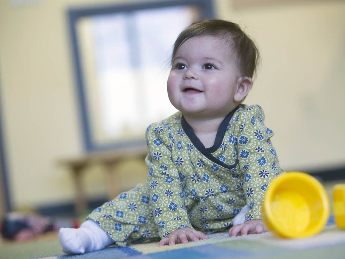 Baby pushing herself up to sit on a playmat