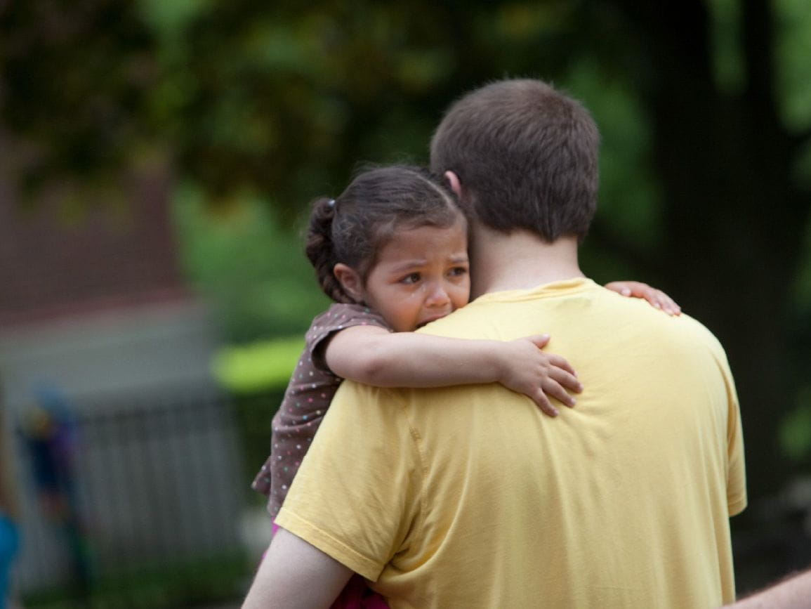 Child being held by adult