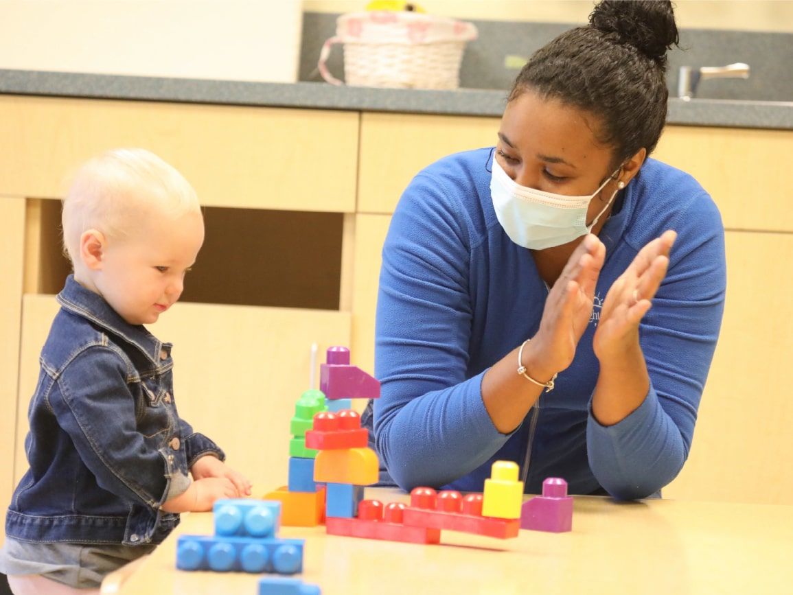 Toddler playing with masked adult