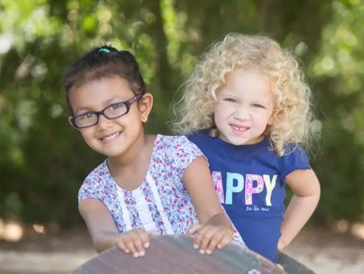 Two young girls make friends at daycare