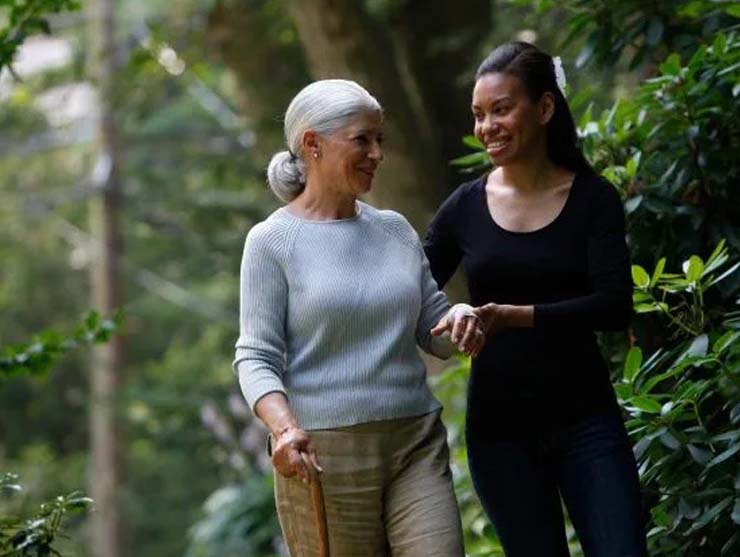 A woman walking with an elderly woman