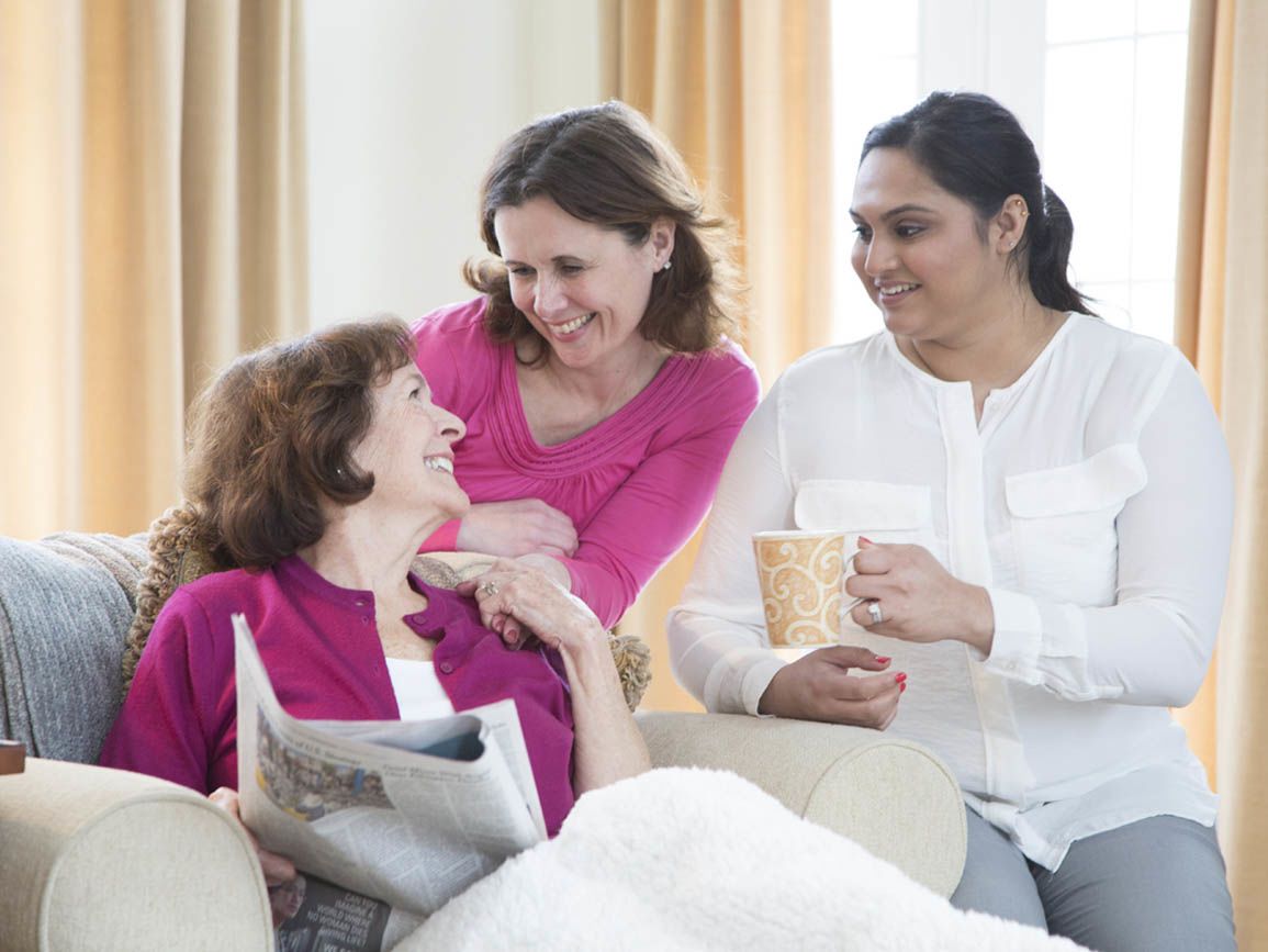 A woman with her elderly mother and caregiver