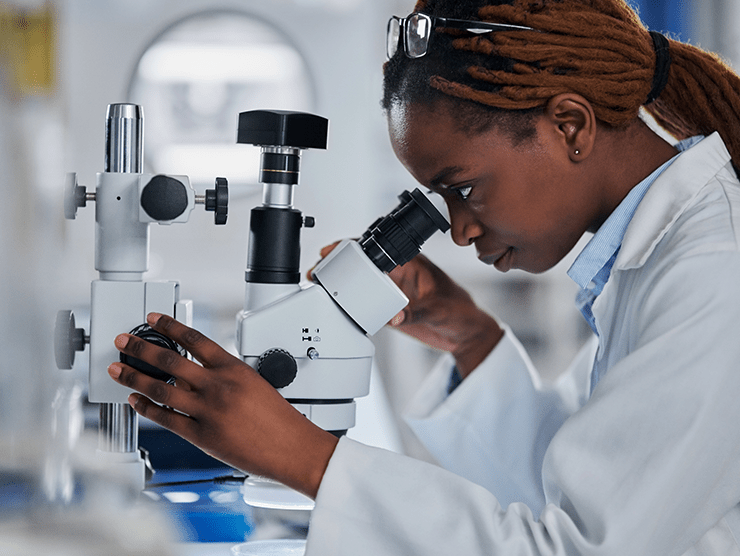 A black female scientist working with a microscope