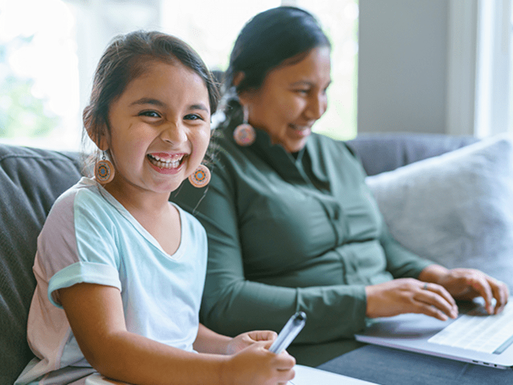 A mother working from home on the couch while her daughter does homework beside her ?? 