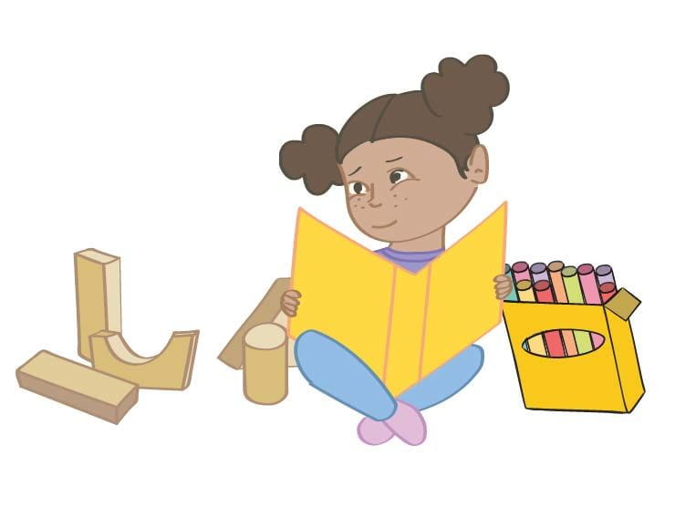 A child sitting with headphones on while reading a book|Little boy reading a book|Cozy space for kids at Bright Horizons daycare|Creating a quiet space for kids