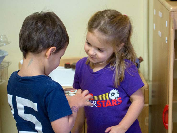 Two preschoolers sharing a toy