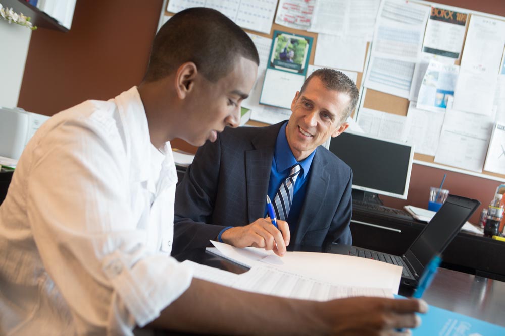 college guidance counselor and high school senior discussing applications