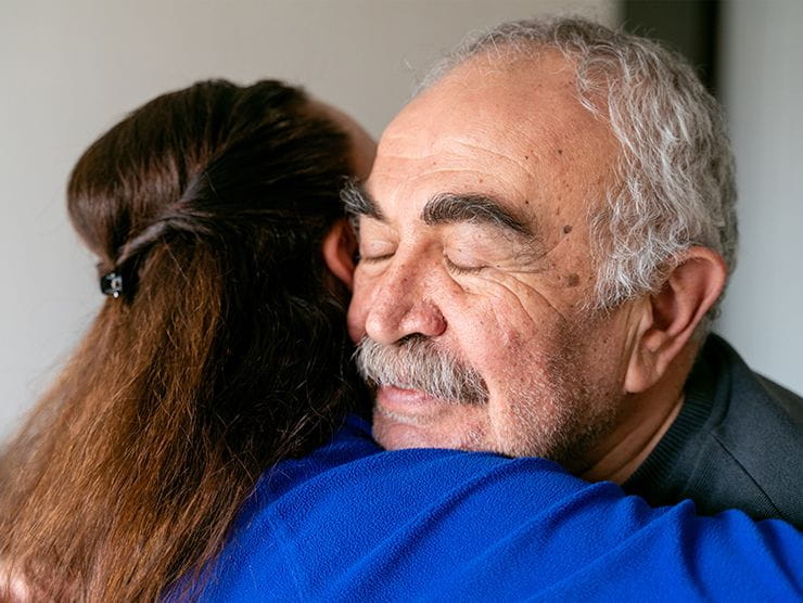 A senior man hugging a woman affectionately. 