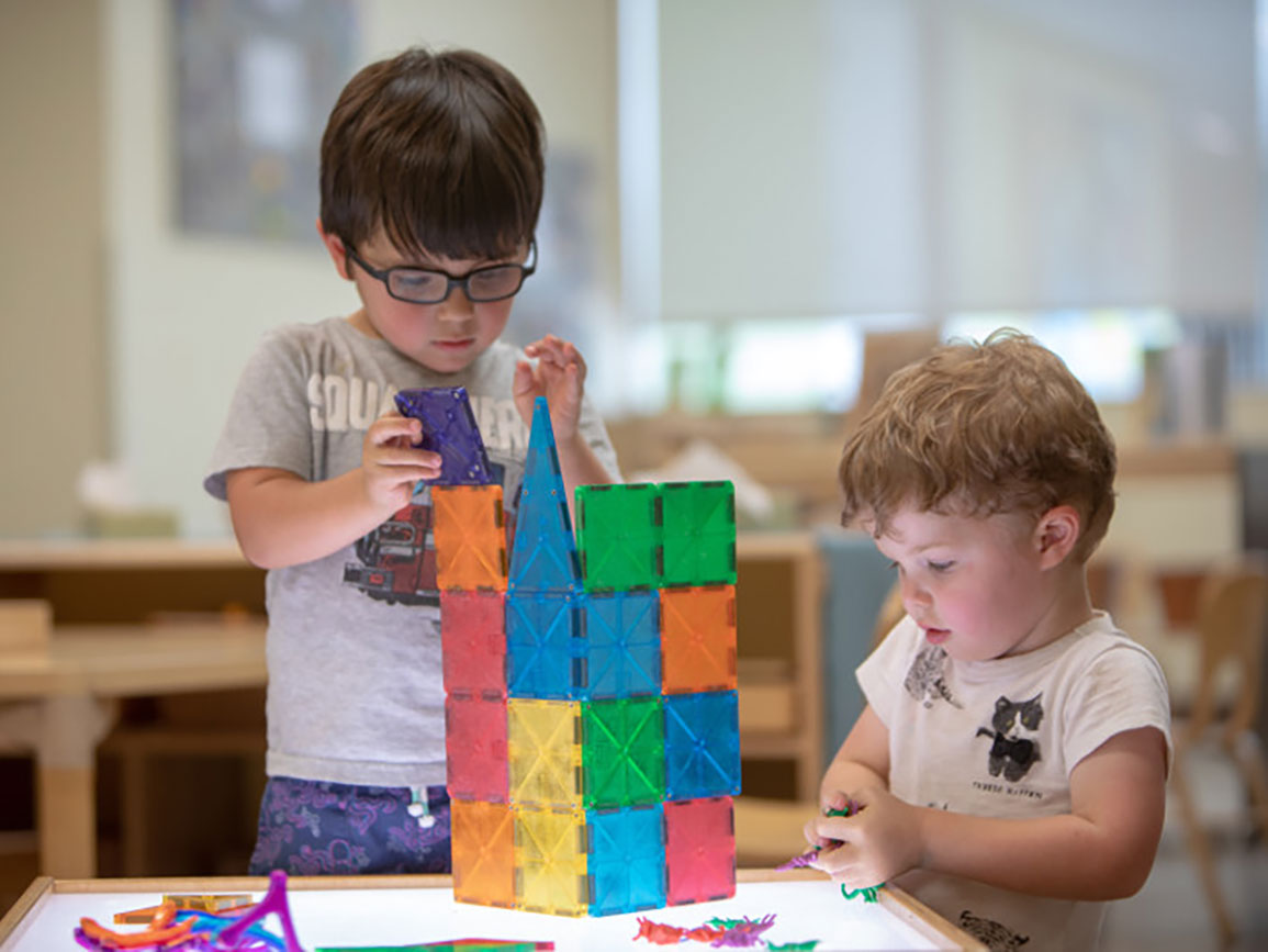 Two preschool boys doing a STEM activity with building squares